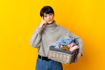 Woman with short hair holding a clothes basket thinking an idea