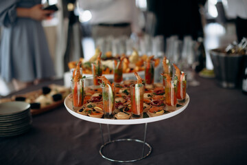 Food, a beautifully decorated catering banquet table with a variety of appetizers with cheese, ham, prosciutto and fruit. At a corporate, Christmas, birthday or wedding celebration. Buffet table. Buff