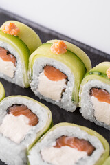 Close-up of sushi rolls made of sausage and covered with cabbage and ketchup. Homemade asian style. Sushi-food hybrids trend. Japanese food