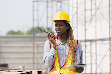 African American female engineer control work by radio communication at construction site