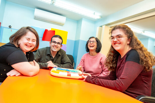 Portrait of happy disabled people playing board games