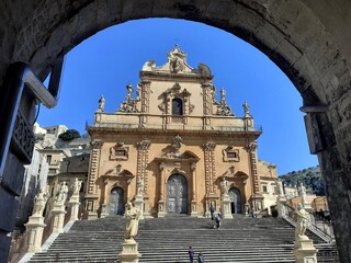 Fototapeta na wymiar Il Duomo di San Pietro a Modica, incorniciato dall'arco di un vicolo.