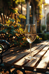 Crystal glass of sparkling wine or champagne on a table at sunlit summer terrace in a vintage style. Summer drinks concept.