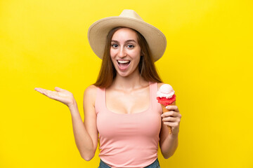 Young caucasian with a cornet ice cream isolated on yellow background with shocked facial expression