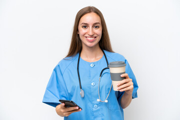 Young nurse woman over isolated on white background holding coffee to take away and a mobile