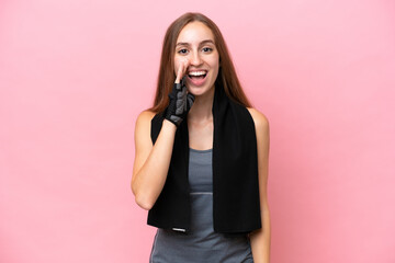 Young sport caucasian woman wearing a towel isolated on pink background shouting with mouth wide...