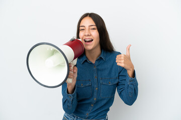 Young French girl isolated on white background shouting through a megaphone to announce something...