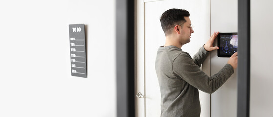 Man using smart home security system indoors
