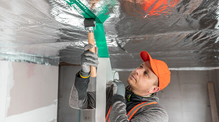 The builder is gluing the special tape on the joint of vapor barriers.  The vapor barrier as...