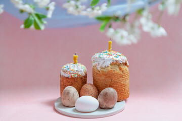 Two pasque with candles and eggs on pink background