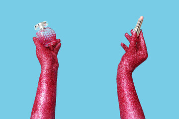 Female hands covered with glitter, bottle of perfume and lipstick on color background, closeup