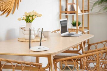 Modern wi-fi router on dining table in light room