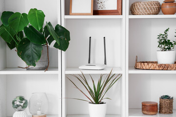 Shelf unit with wi-fi router and plants, closeup