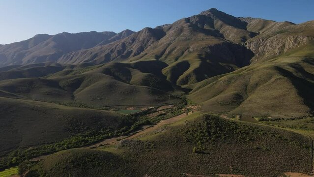 Fly over across the beautiful De Cango South African green landscape with the farms 