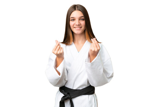 Teenager girl doing karate over isolated chroma key background making money gesture
