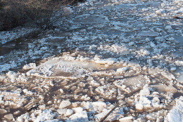 chunks of ice floating in the river on a sunny spring day