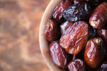 Dried dates in wooden cup. Fruits and healthy food.