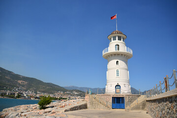 Fototapeta na wymiar white lighthouse on the seafront isolated copy space 
