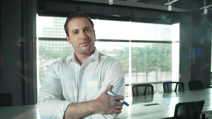 Smart businessman thinking about start up project in front of glass board. Smiling male project...