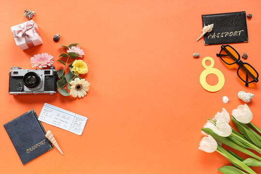 Composition with photo camera, passports and beautiful flowers on color background. International Women's Day