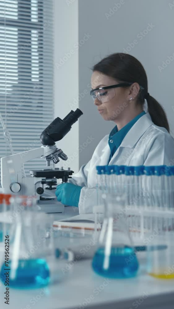Poster An experimental geneticist in the laboratory works with a microscope, develops new methods of genetic therapy for the treatment of various diseases.