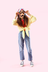 Funny little girl in disguise on pink background. April Fools' Day celebration