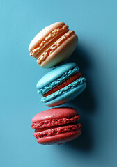 Colorful macarons assorted on blue background close-up view in flat lay style. French pastry with different flavors.