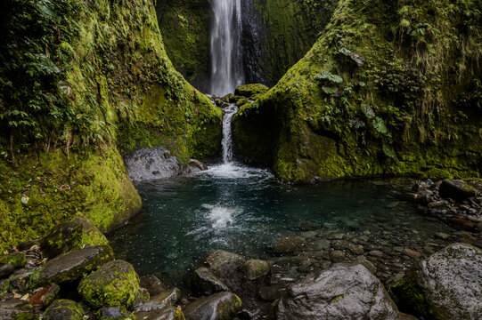 Beautiful aerial footage view of a bajos del toro waterfall in Costa Rica, with a gorgeous woman bathing