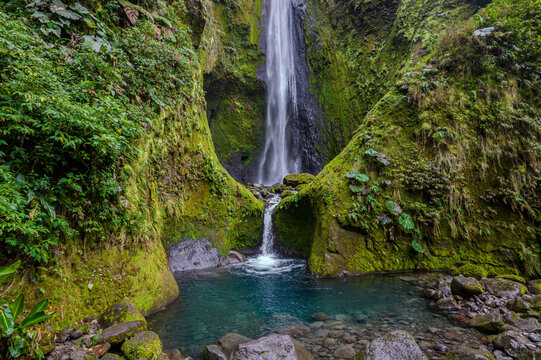 Beautiful aerial footage view of a bajos del toro waterfall in Costa Rica, with a gorgeous woman bathing