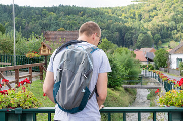 Unrecognizable man enjoins with travel and walking in Austrian village.