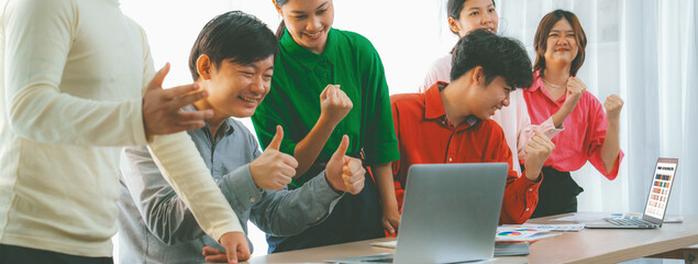 Cropped image of Young creative business team celebrates successful business plan with laptop and...