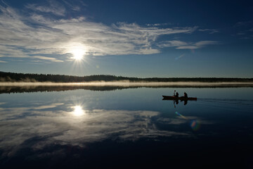 canoeing on lake reflecting mountains