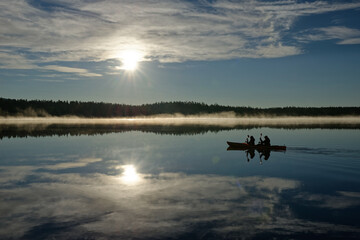 Obraz na płótnie Canvas canoeing on lake reflecting mountains