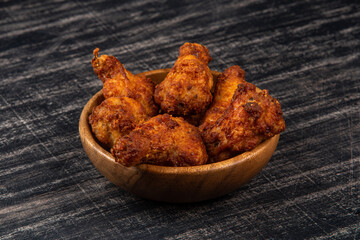 Fried BBQ chicken wings on black background