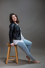 Middle aged brunette woman in jeans studio portrait