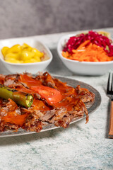iskender kebab. Traditional Turkish cuisine flavor with tomato sauce and butter. iskender kebab on gray background