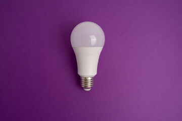 Paper and light bulb on a colored background. Idea and business concept. Place for text
