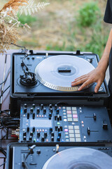 Close-up detail of a DJ's hand turning the turntable of his mixing console