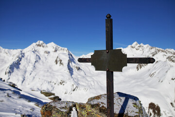 Summit cross in the alps in winter season