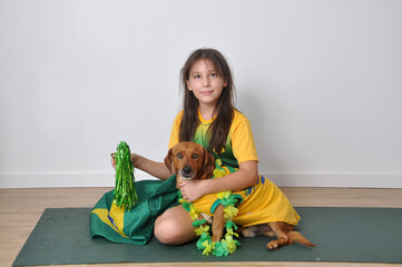 menina feliz com cachorro doméstico vestidos com cores da bandeira do brasil 