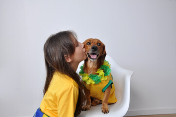 Criança feliz com cachorro caramelo , amor aos animais, cores do brasil no carnaval  