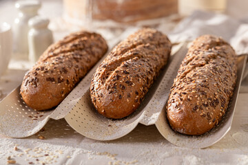 Homemade wholegrain baguettes baked on a special baking tray.