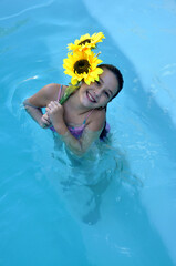 criança sorridente com girassol em piscina férias escolares 