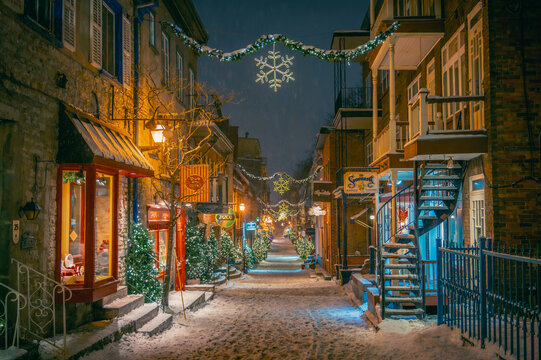 Shops on the historical Petit-Champlain Street with Christmas winter holidays decorations on a snowy night, oldest commercial street in North America, lower town of Old Quebec, Quebec City, Canada. 