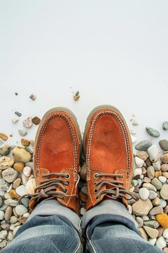 brown worn men's shoes on a background of stones.
