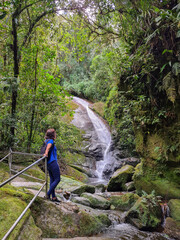 Obraz premium Woman at waterfall in the forest
