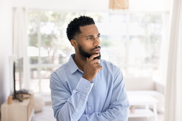 Serious pensive attractive young African man indoor portrait. Thoughtful handsome business...