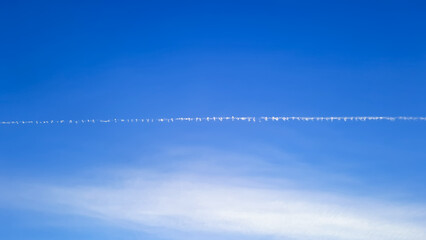 commercial plane tracks in a blue sky