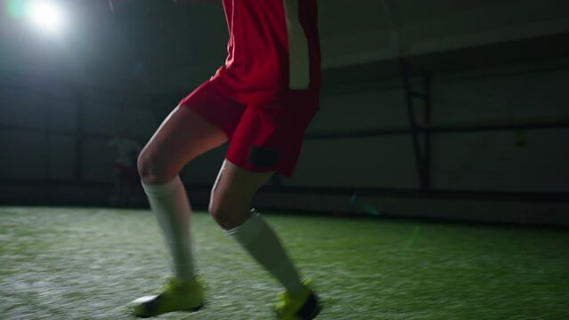 Active Teen Girl Footballer Running On Indoors Field And Kicking Ball To Gate, Junior Soccer Player