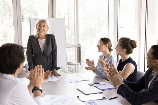 Group of young multiethnic people welcoming business trainer with ovations, express respect and gratitude for received knowledge finish seminar educational corporate training in modern conference room